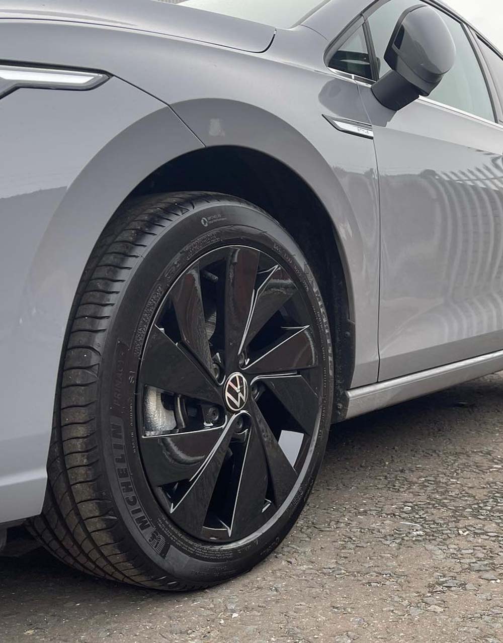 Black Volkswagon alloy wheel on grey Golf